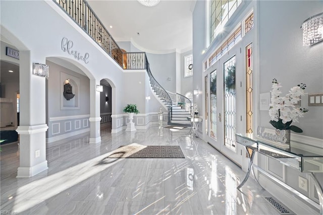 foyer with a towering ceiling and decorative columns