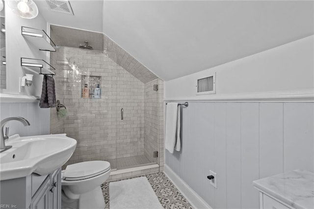 bathroom with tile patterned flooring, vanity, toilet, and a shower with shower door