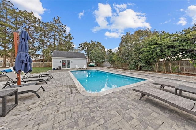 view of pool featuring an outbuilding and a patio