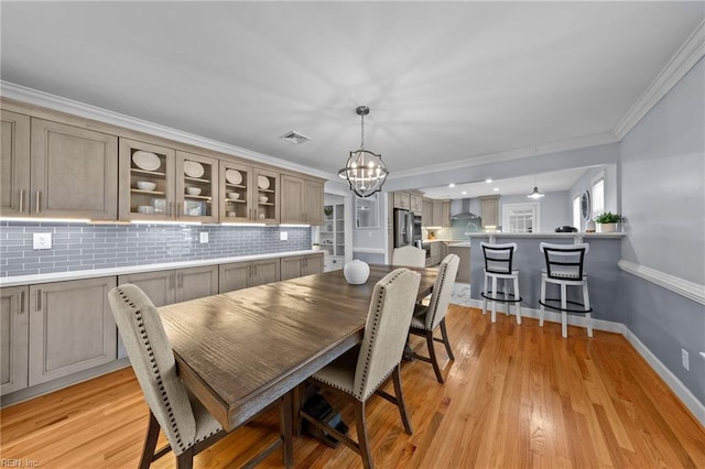 dining room featuring a notable chandelier, crown molding, and light hardwood / wood-style floors