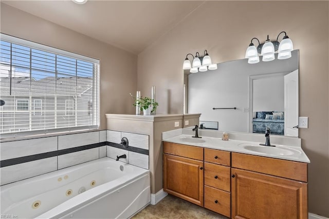 bathroom with vaulted ceiling, vanity, a bathing tub, and tile patterned floors