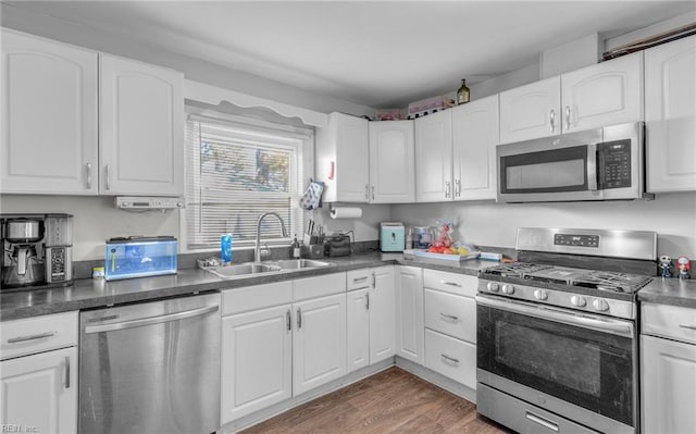 kitchen featuring sink, dark wood-type flooring, white cabinets, and appliances with stainless steel finishes