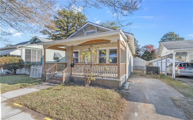 bungalow-style house with a carport, a front yard, and covered porch