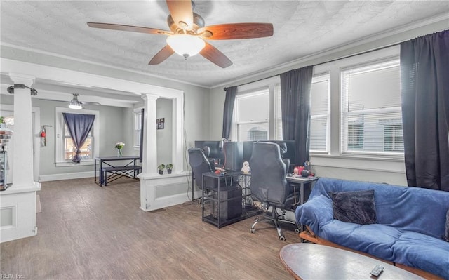 living room featuring crown molding, decorative columns, hardwood / wood-style floors, and a textured ceiling