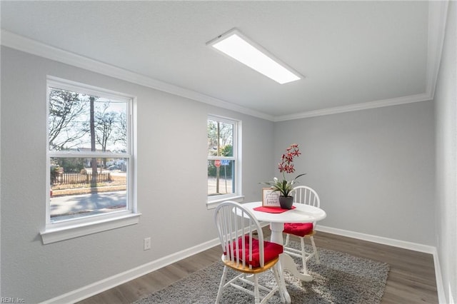 dining space with dark hardwood / wood-style flooring and crown molding