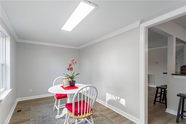 dining room featuring hardwood / wood-style flooring and ornamental molding