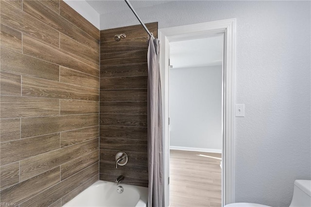 bathroom featuring shower / bath combo and toilet