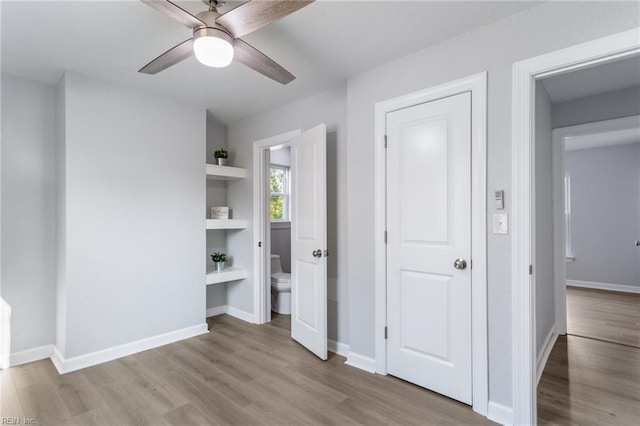 unfurnished bedroom with light wood-type flooring, connected bathroom, and ceiling fan