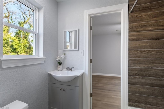 bathroom with hardwood / wood-style flooring, vanity, and toilet