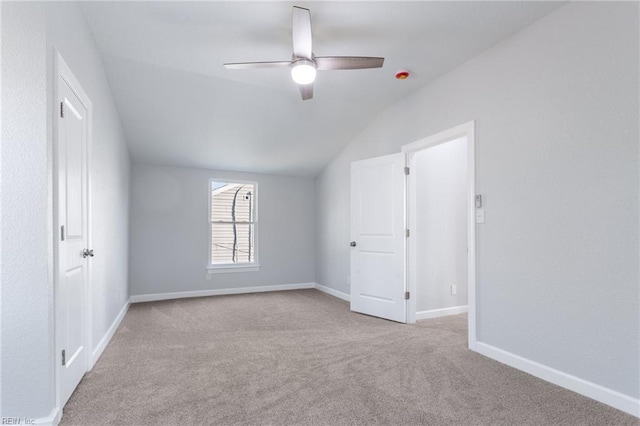 unfurnished room featuring ceiling fan, light colored carpet, and vaulted ceiling