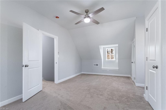 additional living space with ceiling fan, vaulted ceiling, and light carpet