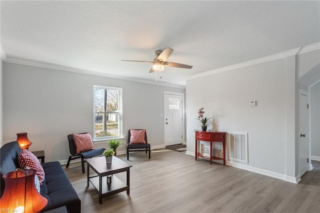 living room with ornamental molding, wood-type flooring, and ceiling fan