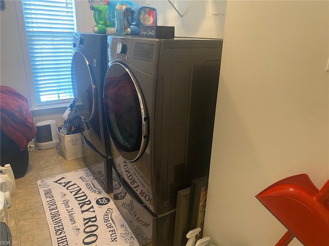 laundry area with separate washer and dryer and light tile patterned floors