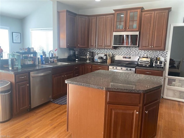 kitchen featuring light hardwood / wood-style floors, sink, stainless steel appliances, and a center island