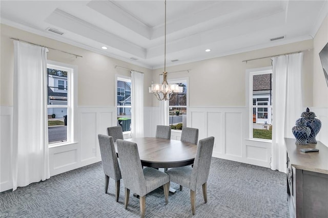 carpeted dining space featuring a notable chandelier, crown molding, and a raised ceiling