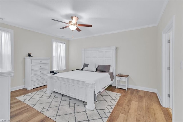 bedroom with crown molding, light hardwood / wood-style flooring, and ceiling fan