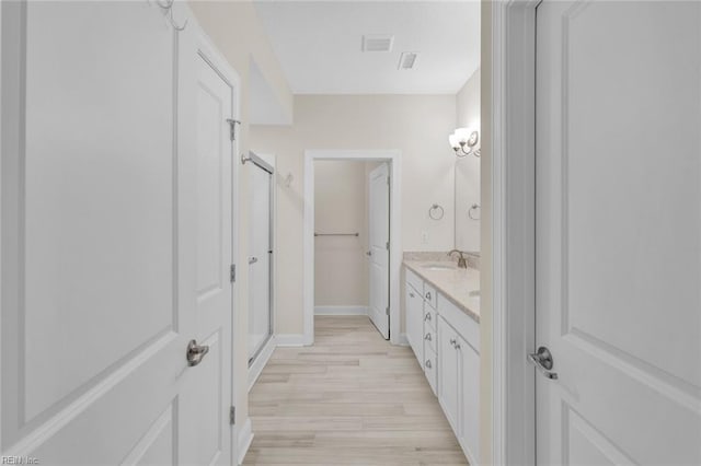 bathroom featuring vanity, hardwood / wood-style floors, and a shower with shower door