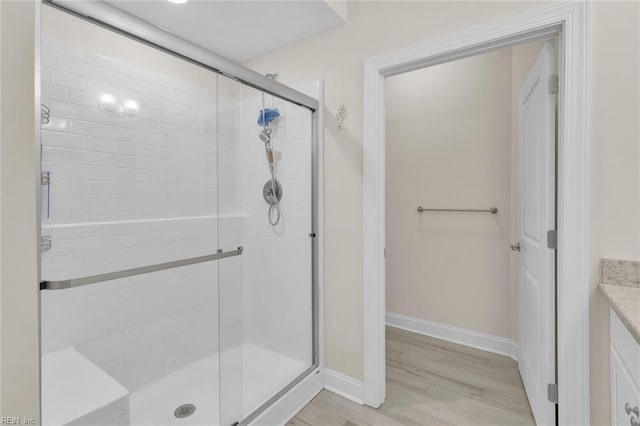 bathroom with wood-type flooring, an enclosed shower, and vanity