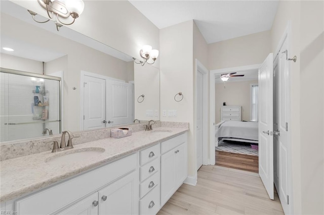 bathroom with vanity, hardwood / wood-style floors, ceiling fan, and walk in shower