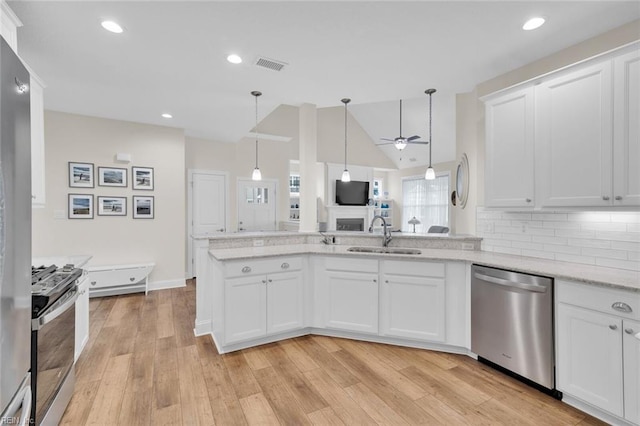 kitchen with sink, white cabinetry, pendant lighting, stainless steel appliances, and decorative backsplash