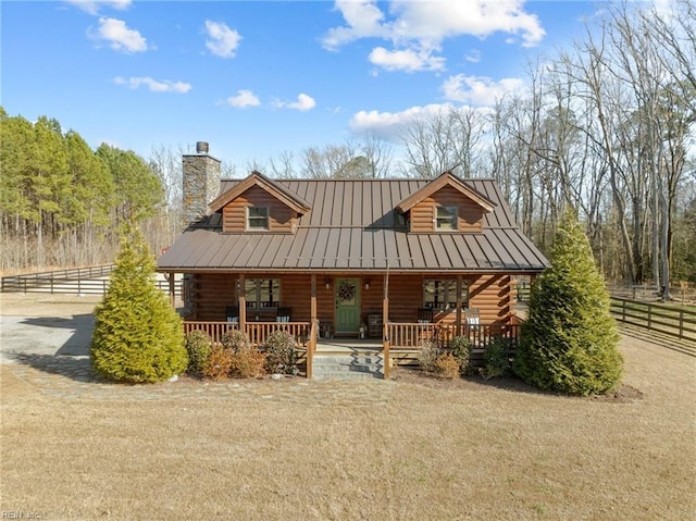 log cabin with a porch and a front lawn