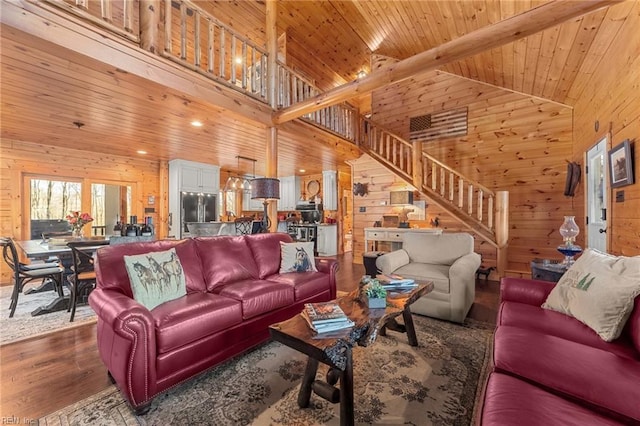 living room with hardwood / wood-style flooring, high vaulted ceiling, wooden ceiling, and wooden walls