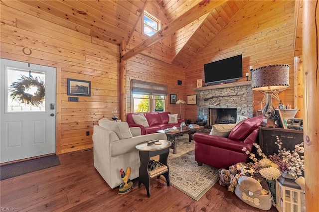 living room with wooden walls, wood-type flooring, and a stone fireplace