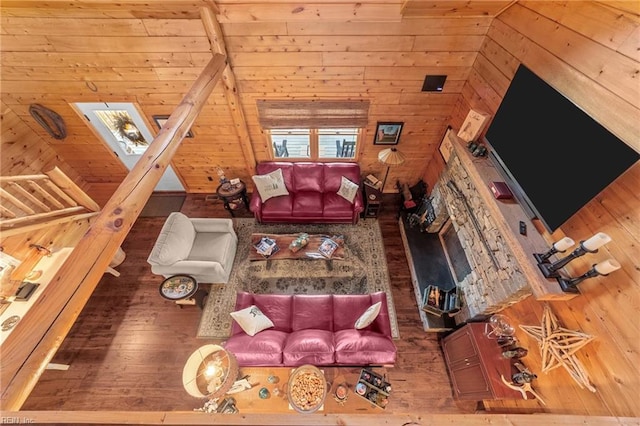 unfurnished living room featuring a skylight, hardwood / wood-style floors, and wood walls