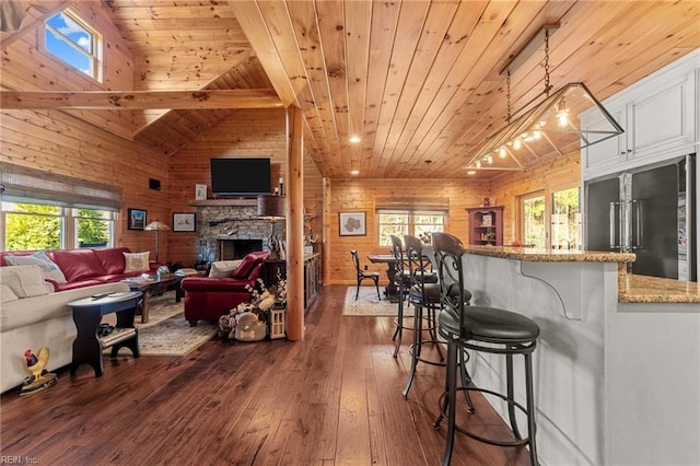 living room with wood ceiling, a fireplace, dark wood-type flooring, and a wealth of natural light