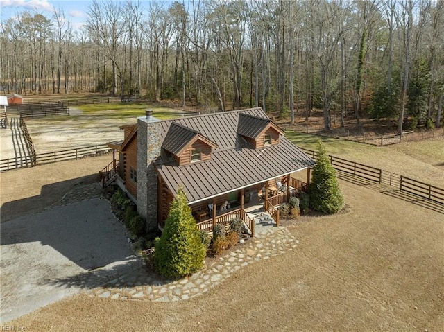 view of home's exterior with a rural view, a lawn, and a porch