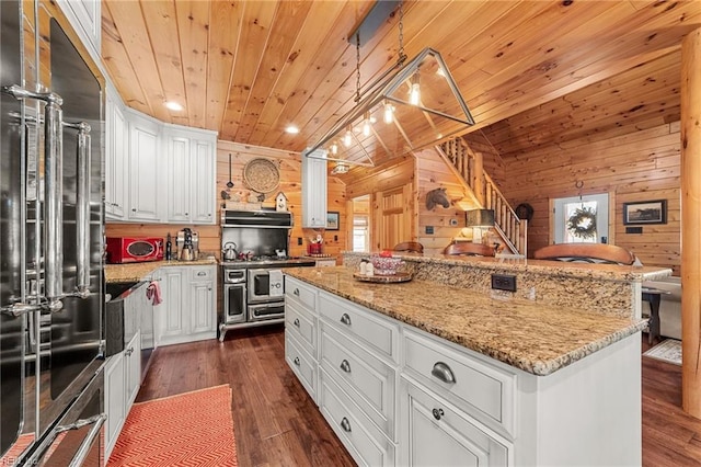 kitchen with pendant lighting, stainless steel appliances, a center island, and white cabinets