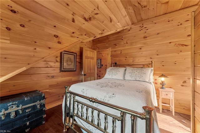 bedroom with hardwood / wood-style floors, wood ceiling, and wooden walls