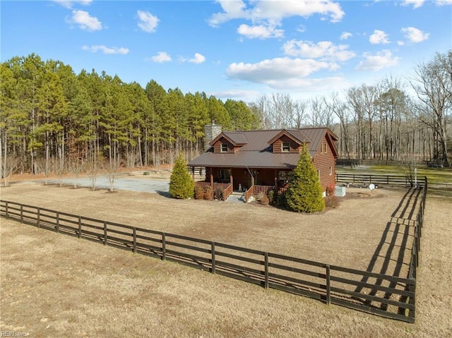 view of front of property with a rural view and a front lawn