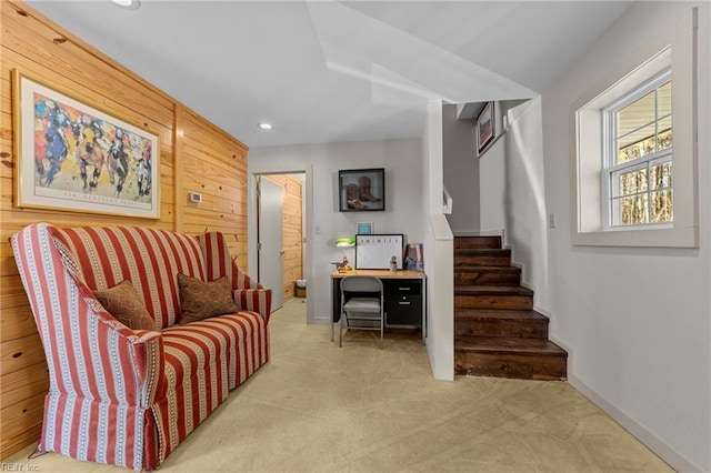 sitting room with wooden walls and light colored carpet