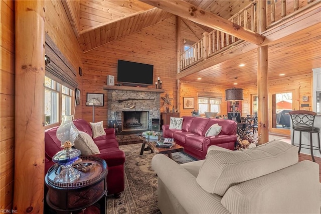 living room featuring wood ceiling, a stone fireplace, high vaulted ceiling, and wood walls