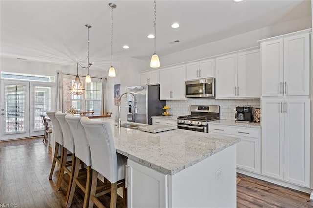 kitchen featuring white cabinetry, appliances with stainless steel finishes, and a kitchen island with sink