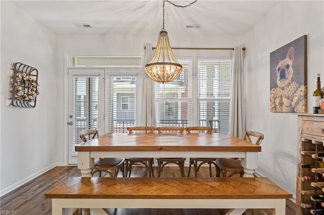 dining room featuring dark wood-type flooring and a chandelier