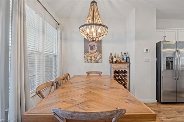 dining area with an inviting chandelier and light hardwood / wood-style flooring