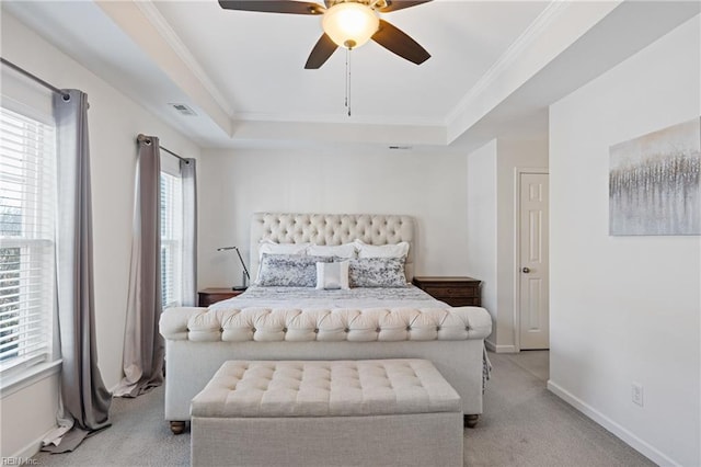 carpeted bedroom with crown molding, ceiling fan, and a tray ceiling