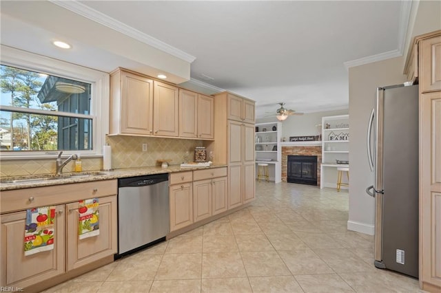 kitchen featuring sink, stainless steel appliances, crown molding, light stone countertops, and light brown cabinets