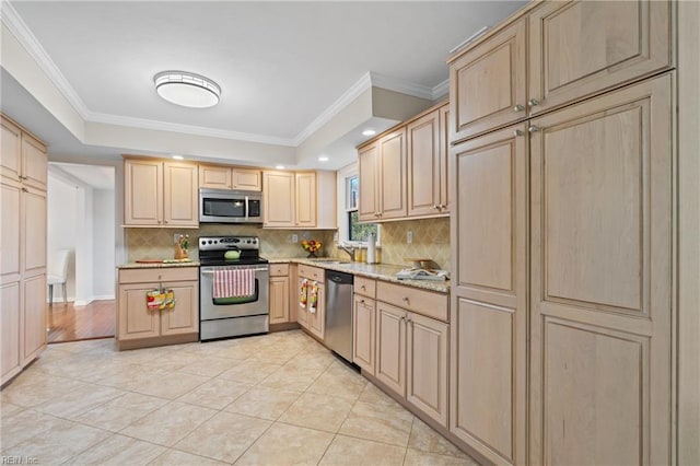 kitchen with appliances with stainless steel finishes, sink, and light brown cabinetry