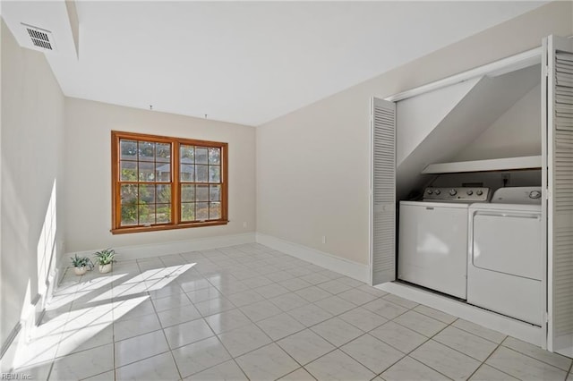 clothes washing area featuring light tile patterned floors and washing machine and dryer