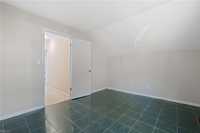 bonus room featuring vaulted ceiling and dark tile patterned floors