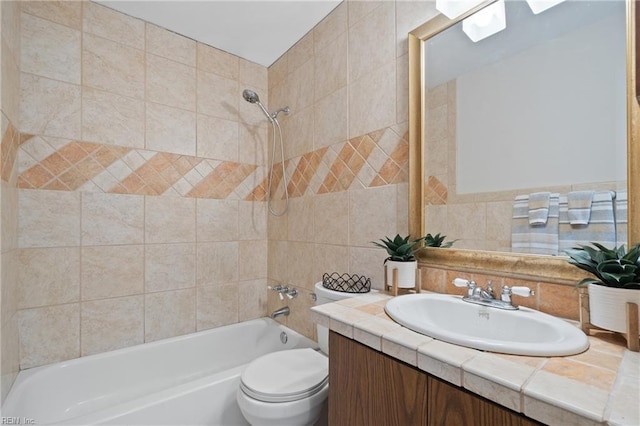 full bathroom with tile walls, vanity, tiled shower / bath combo, and toilet