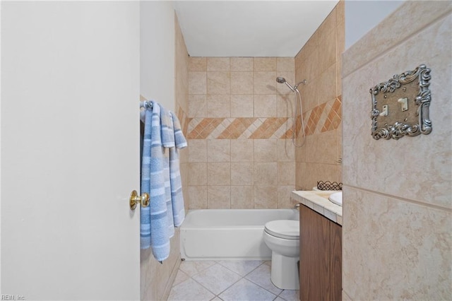 full bathroom with tile patterned flooring, vanity, tiled shower / bath, and toilet