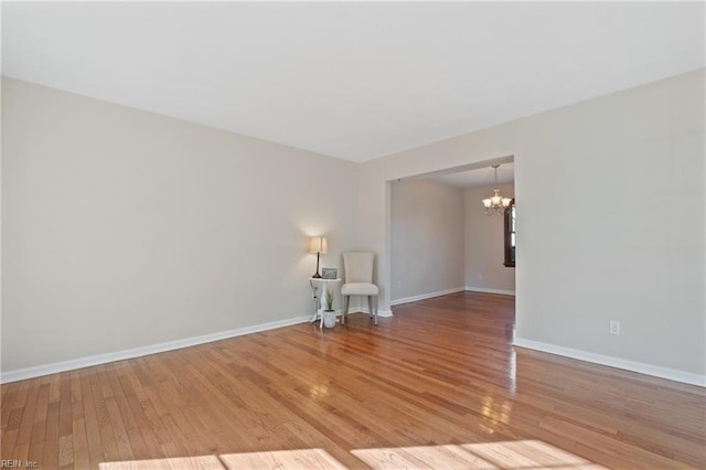 empty room featuring hardwood / wood-style floors and an inviting chandelier