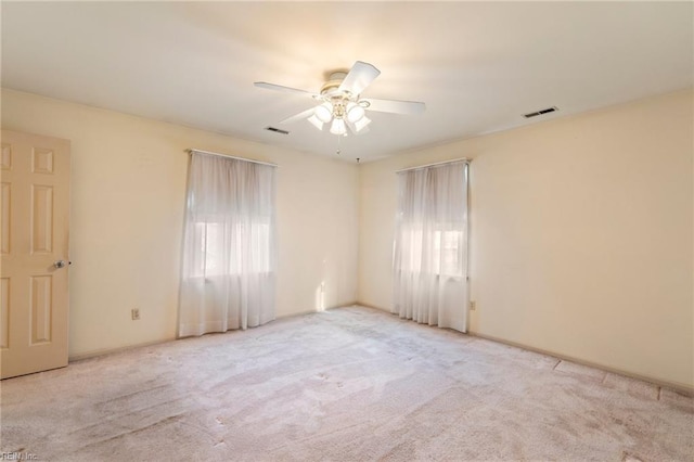 empty room featuring ceiling fan and light carpet