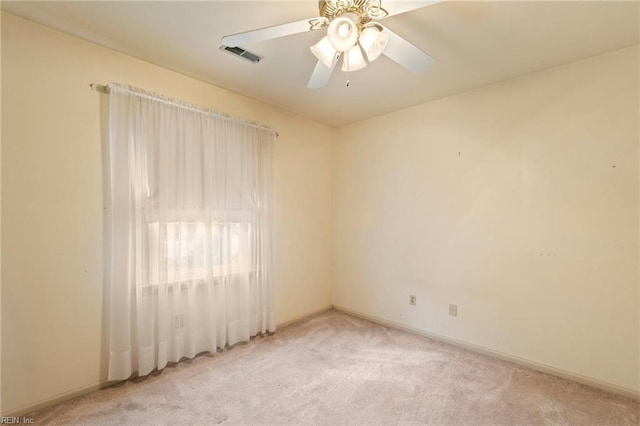 spare room featuring light carpet and ceiling fan