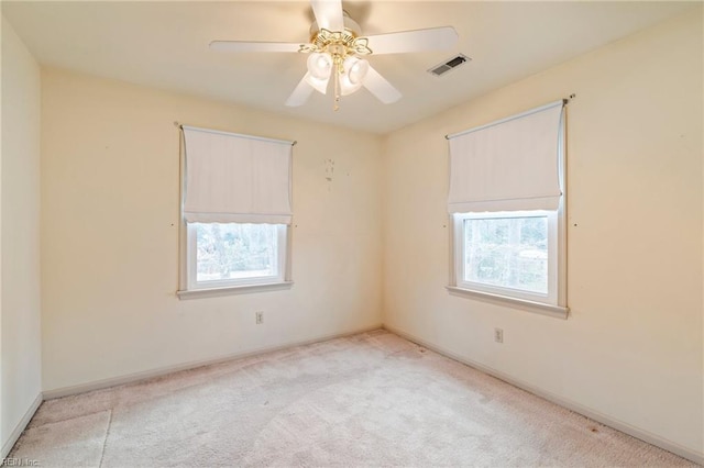 carpeted empty room featuring a wealth of natural light and ceiling fan