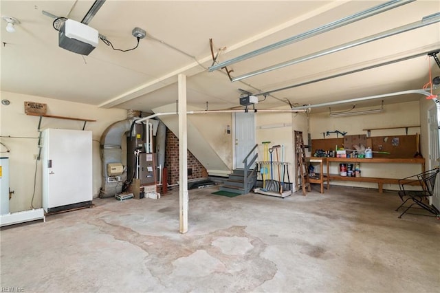 garage with a workshop area, a garage door opener, water heater, and heating unit